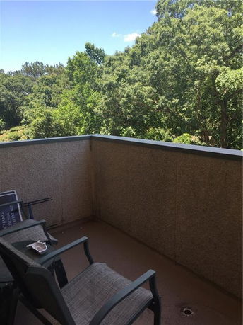 Balcony view with surrounding trees.