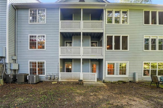 Rear view of a multi-story residential building with balconies and multiple windows.