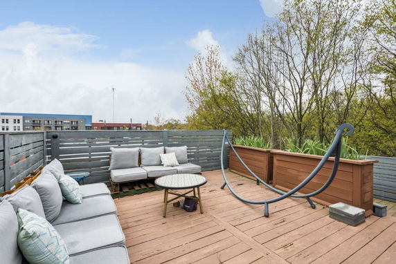 Rooftop with outdoor seating and a hammock structure.