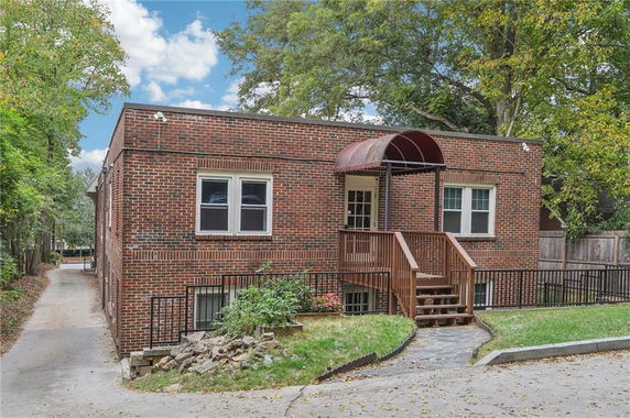 Front view of a brick single-story house with a small porch and staircase.