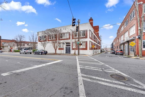 Street view of a two-story building with brick and white exterior.