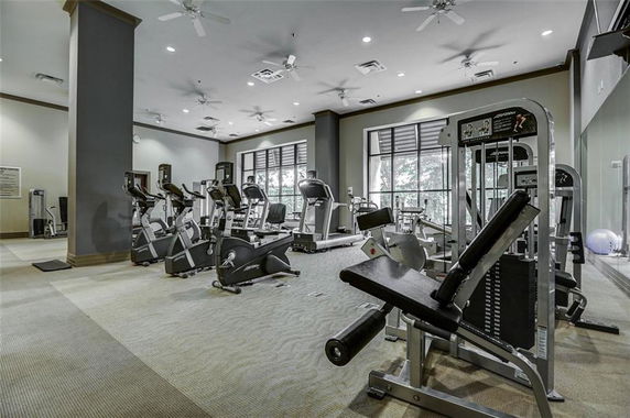Indoor gym area with exercise equipment and machines.