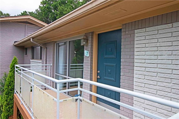 Front view of a building entrance with a blue door and railing.