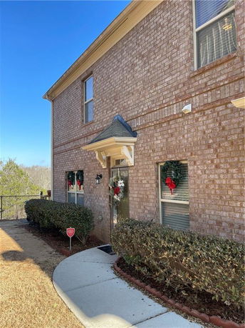 Front view of a two-story brick house with a small entrance porch.