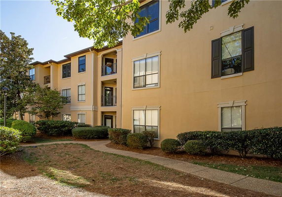 Front view of a multi-story apartment building with beige exterior.