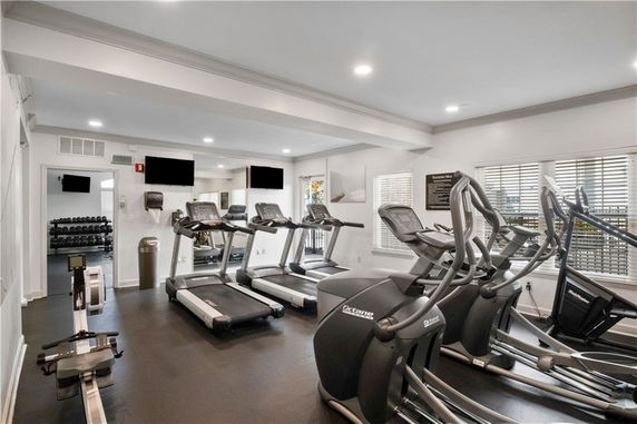 Indoor gym area with exercise equipment including treadmills and ellipticals.