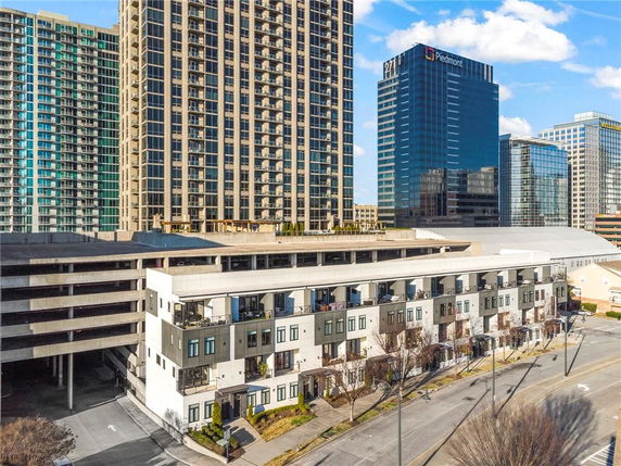 Front view of a multi-story building with retail or office spaces and large windows.