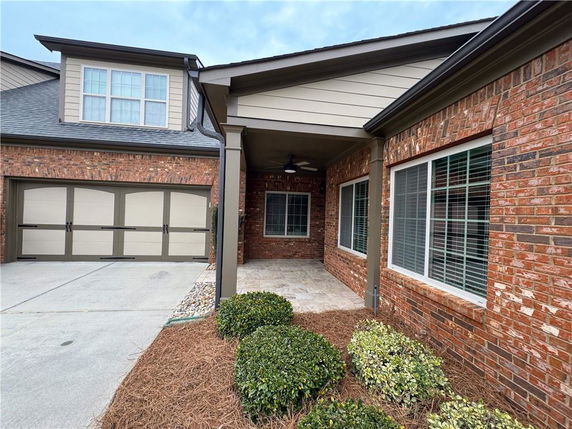 Front view of a brick house with two-car garage and covered porch.