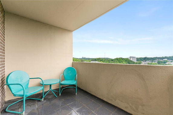 View from a shaded balcony with turquoise chairs.