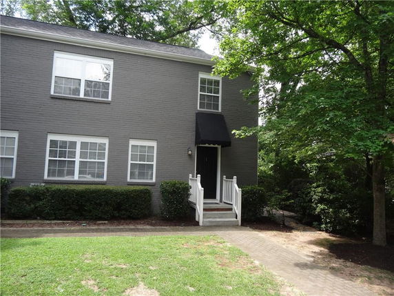 Front view of a two-story house with gray brick exterior and white trim.