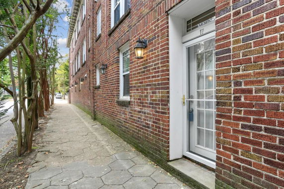 Side view of a brick building with multiple windows and a white door.