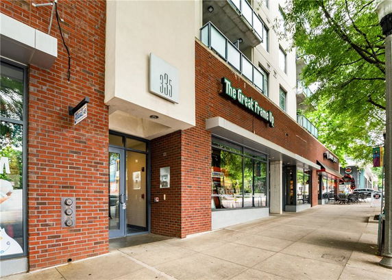 Front view of a commercial building with glass windows and brick facade.