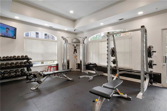 Indoor gym area with exercise equipment including weights and benches.
