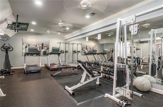 Indoor gym area with exercise equipment including treadmills and weight benches.