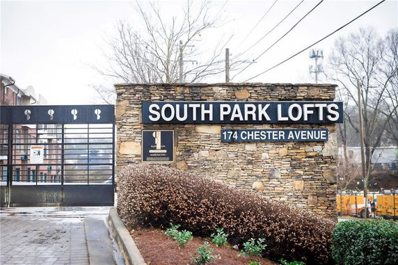 Front view of the entrance to South Park Lofts with a stone wall and signage.