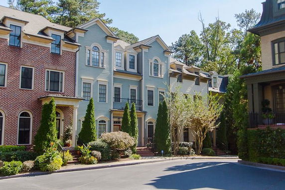 Front view of a multi-story townhouse with brick and siding exterior.
