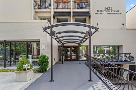 Front view of a residential condominium building with a covered entrance walkway.