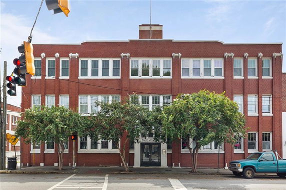 Front view of a three-story brick building with multiple windows and a central entrance.