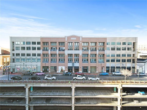 Front view of a multi-story commercial building with a symmetrical facade and large windows.