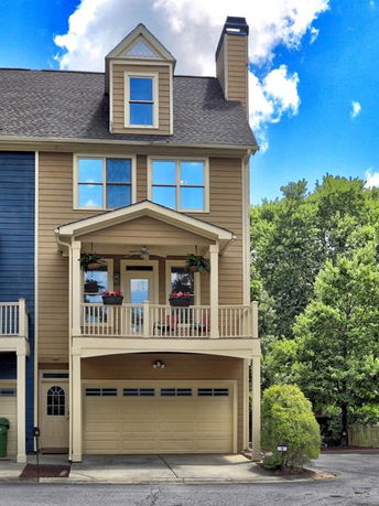 Front view of a multi-story house with a garage and balcony.