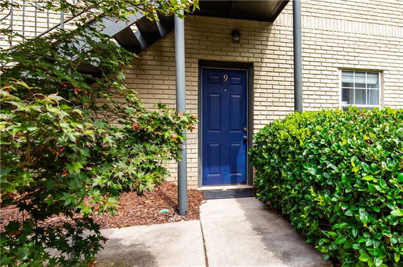 Front view of a building entrance with a blue door numbered 9.