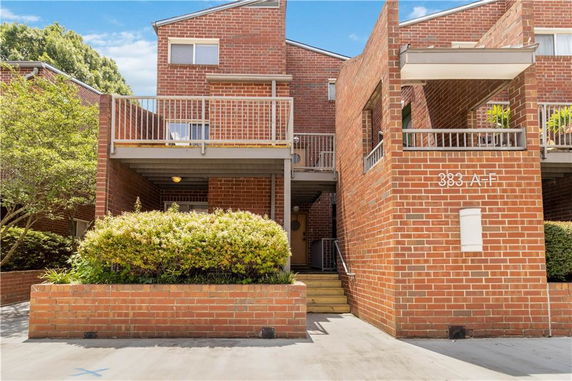 Front view of a brick residential building with balconies.