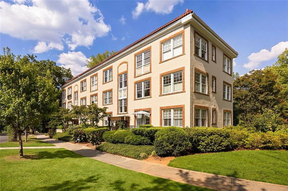Front view of a three-story apartment building with large windows.