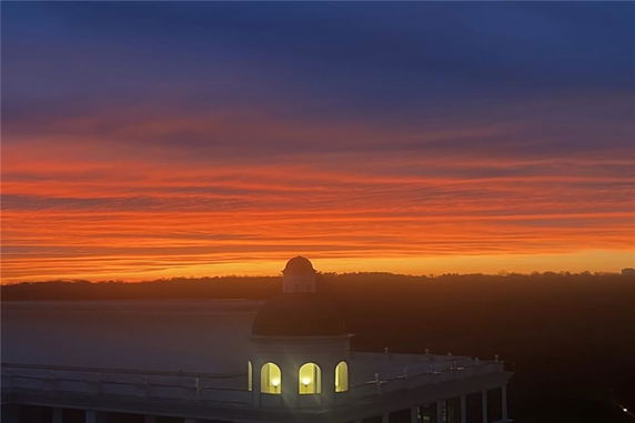 Panoramic view showing a rooftop against a vibrant sunset sky.