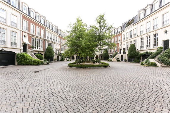 Front view of multi-story residential buildings surrounding a courtyard.