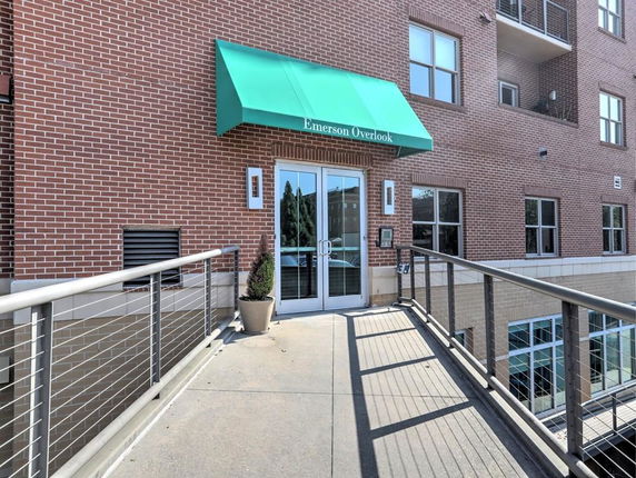 Front view of a brick building entrance with a green awning.