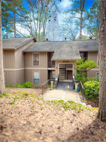 Front view of a two-story house with wooden siding and a central entrance.