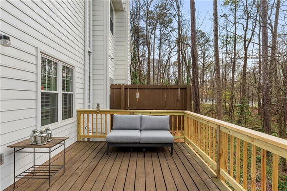View from a wooden deck attached to a house, overlooking a forested area.