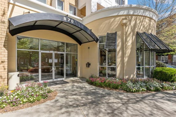 Front view of a building entrance with large glass doors and an awning.