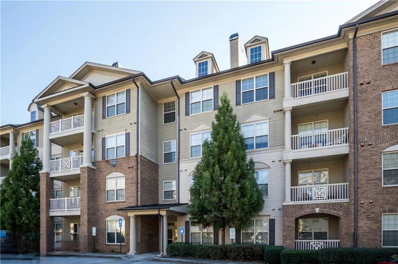 Front view of a multi-story apartment building with balconies.