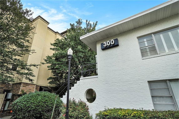 Front view of a white two-story building with a visible number 300 on the wall.