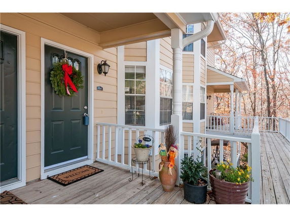 Front view of a house with a porch and decorative plants.