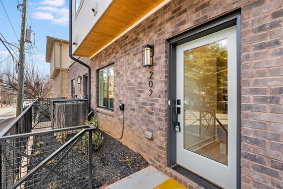 Front view of a brick house with a modern entrance door and windows.