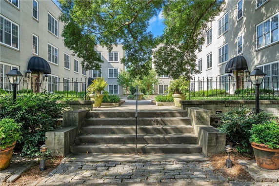 Elevated view of a multi-story building with large windows and outdoor staircase.