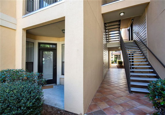 View of the entrance to a residential apartment unit with stairs leading to the upper floor.