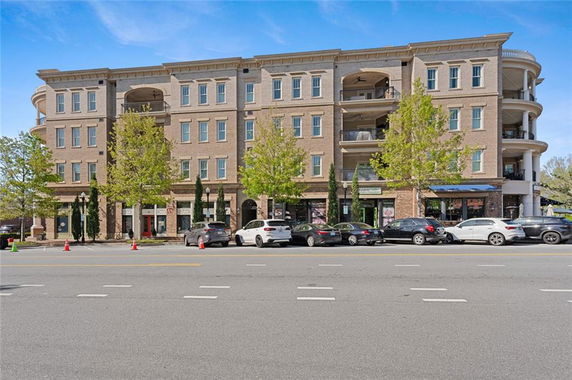 Front view of a multi-story building with a brick facade and balconies.