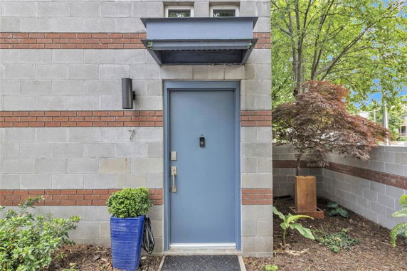 Front view of a house with a blue door and brick accents.