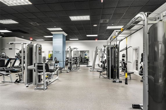 Interior view of a fitness gym with various exercise machines and equipment.