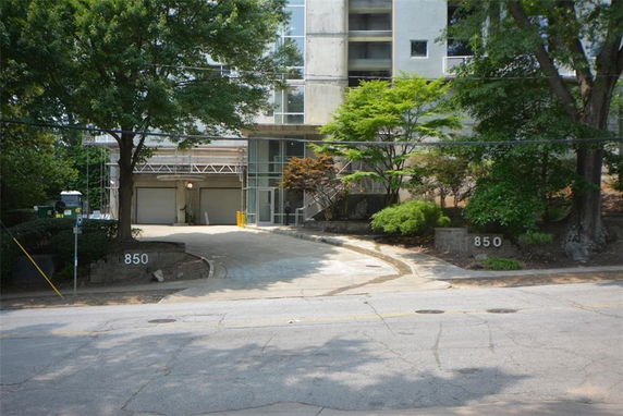 Front view of a building with a driveway and garage doors.