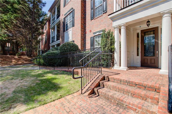 Front view of a multi-story brick building with a columned entrance.