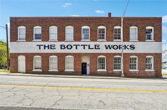 Front view of a two-story brick building with a sign reading 'The Bottle Works'.
