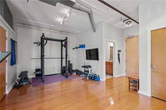Indoor gym area with exercise equipment and a wall-mounted TV.