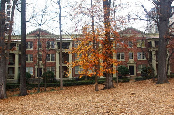 Front view of a large brick building with symmetrical windows and columns.