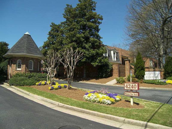 Front view of a house with a unique turret structure and a sign indicating it's for sale.