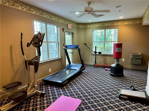 Room with fitness equipment including a treadmill and elliptical machine.