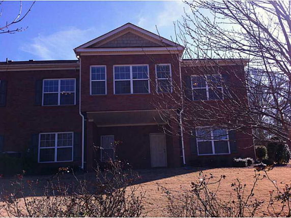 Front view of a two-story brick house with multiple windows.
